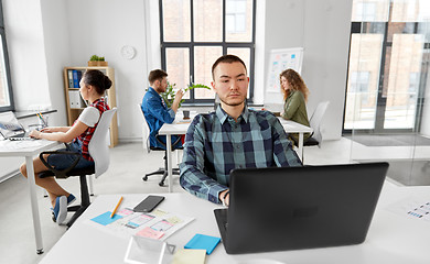 Image showing creative man with laptop working at office