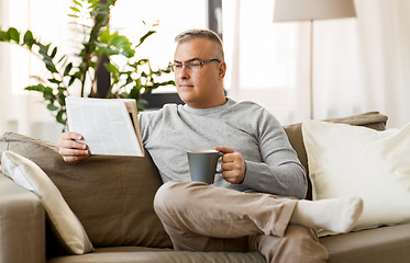 Image showing man reading newspaper and drinking coffee at home