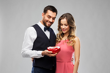 Image showing happy couple with chocolate box in shape of heart