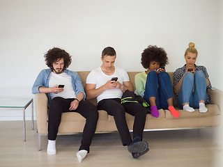 Image showing multiethnic group of young people staring at smartphone