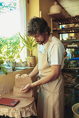 Image showing Creating a jar or vase of white clay close-up. Master crock.