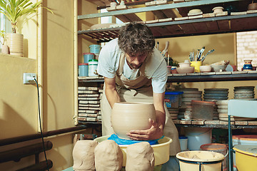 Image showing Creating a jar or vase of white clay close-up. Master crock.