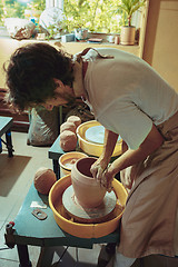 Image showing Creating a jar or vase of white clay close-up. Master crock.