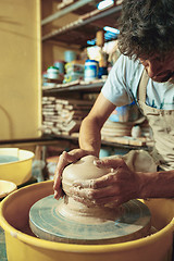 Image showing Creating a jar or vase of white clay close-up. Master crock.