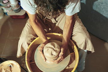 Image showing Creating a jar or vase of white clay close-up. Master crock.