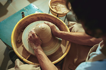 Image showing Creating a jar or vase of white clay close-up. Master crock.