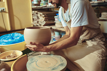 Image showing Creating a jar or vase of white clay close-up. Master crock.
