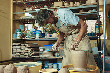 Image showing Creating a jar or vase of white clay close-up. Master crock.