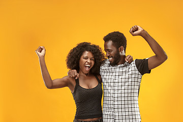 Image showing Winning success couple celebrating being a winner. Dynamic energetic image of afro models