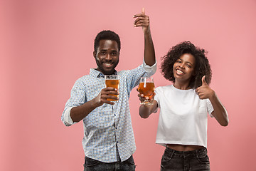 Image showing The afro couple or happy young people laughing and drinking beer at studio