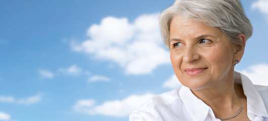 Image showing portrait of smiling senior woman over blue sky