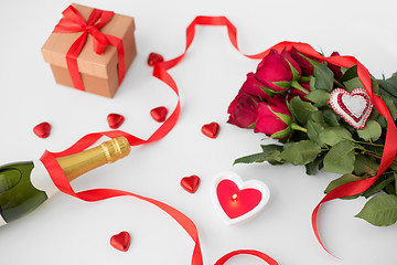 Image showing close up of champagne, gift, candies and red roses