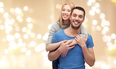 Image showing smiling couple hugging over festive lights