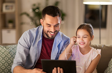Image showing father and daughter listening to music on tablet