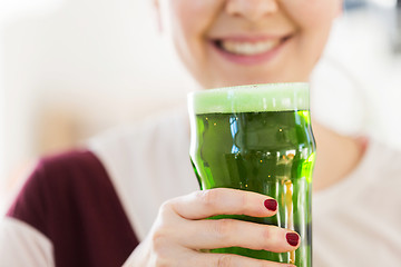 Image showing close up of woman with green beer in glass