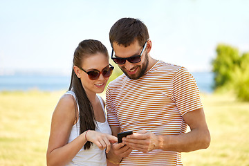 Image showing happy couple with smartphone in summer