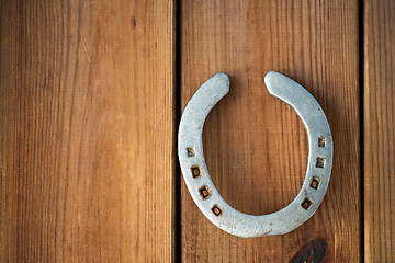 Image showing old horseshoe on wooden background