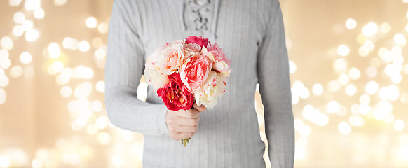 Image showing close up of man holding flowers over lights