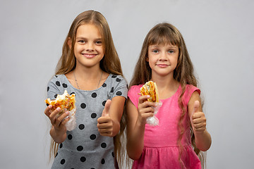 Image showing Two girls eat bread and show class