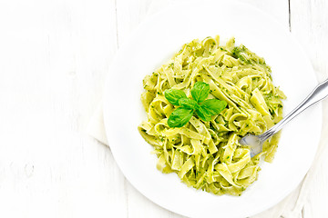 Image showing Pasta with pesto sauce in plate on board top