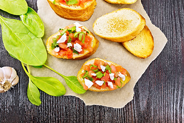 Image showing Bruschetta with tomato and cheese on dark board top