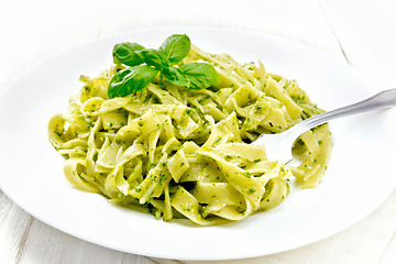 Image showing Pasta with pesto sauce in plate on light board