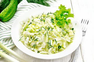 Image showing Salad of cabbage and cucumber in plate on white board