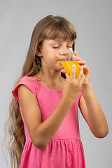 Image showing Girl drinking orange juice from a glass