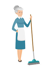 Image showing Senior housemaid sweeping floor with a broom.