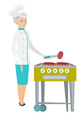 Image showing Caucasian chef cooking steak on barbecue grill.
