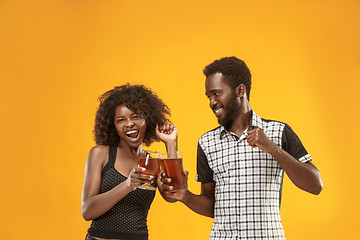 Image showing The afro couple or happy young people laughing and drinking beer at studio
