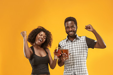 Image showing The afro couple or happy young people laughing and drinking beer at studio