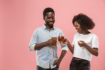 Image showing The afro couple or happy young people laughing and drinking beer at studio