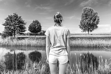 Image showing Young woman wearing casual summer clothes enjoying beautiful view of peaceful countryside.