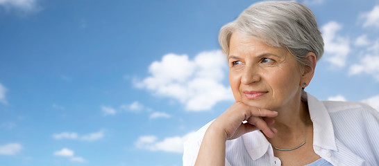 Image showing portrait of pensive senior woman over blue sky