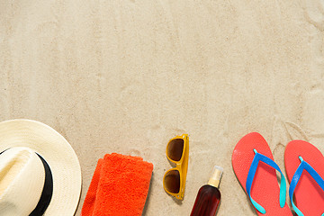 Image showing straw hat, flip flops and sunglasses on beach sand