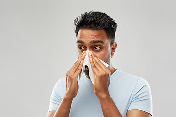 Image showing indian man with paper napkin blowing nose