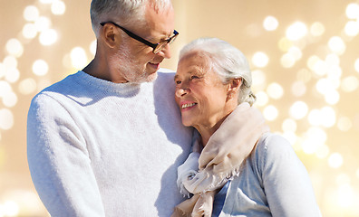 Image showing happy senior couple over festive lights background