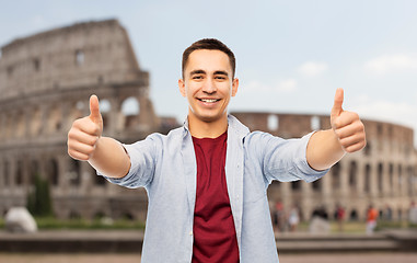 Image showing happy young man showing thumbs up over coliseum