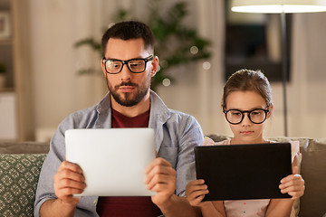 Image showing father and daughter with tablet computers at home