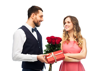 Image showing happy man giving woman flowers and present