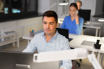Image showing man with computer working at night office