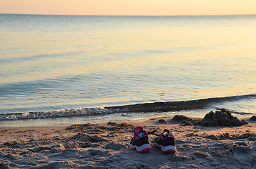 Image showing Shoes by seaside on a beach by sunset