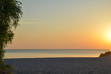 Image showing Sunset by a beautiful empty sand beach