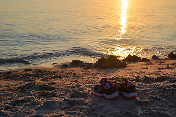 Image showing Shoes by seaside on a sandy beach