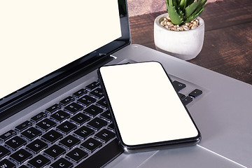 Image showing Smartphone white blank screen on laptop keyboard
