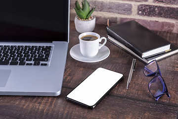 Image showing Laptop notebook with blank screen and cup of coffee and notepad 