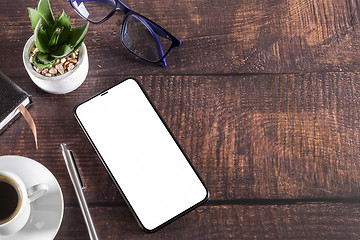 Image showing Working table with smart phone notepad coffee cup pen glasses pl