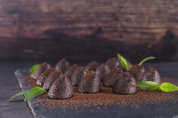 Image showing Homemade chocolate truffles with mint sprinkled with cocoa powde