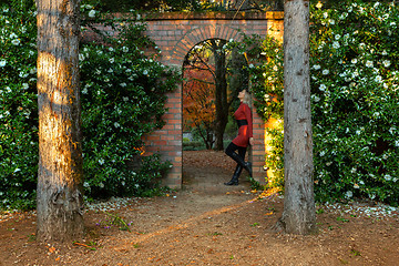 Image showing Woman standing in beautiful stone garden arch